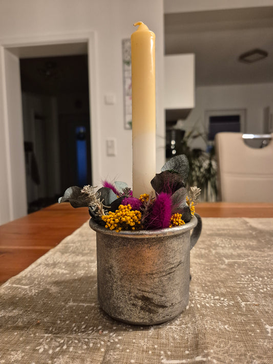 Kerzenhalter Tasse in Silber mit Kerze und Trockenblumen dekoriert.